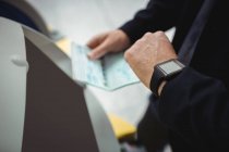 Mãos de homem de negócios usando máquina de check-in de auto-atendimento no aeroporto — Fotografia de Stock
