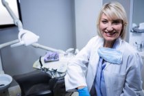 Портрет уверенного стоматолога, сидящего рядом со стулом в стоматологической клинике — стоковое фото