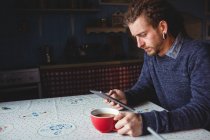 Hipster usando tablet digital enquanto toma chá em casa — Fotografia de Stock