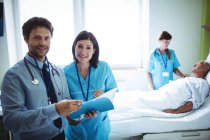 Чоловік лікар і медсестра взаємодіють над звітом у лікарні — стокове фото
