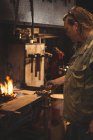 Кузнец нагревает металлический кусок в кузнечном огне на рабочем месте — стоковое фото