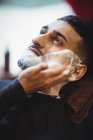 Mann rasiert sich im Friseurladen den Bart — Stockfoto