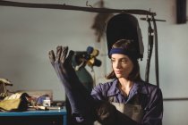 Femme soudeuse portant un gant en atelier — Photo de stock