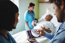 Чоловічий доктор і медсестра, використовуючи цифровий планшетний в лікарні — стокове фото