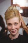 Peluquería clientes de peinado cabello con spray en el salón - foto de stock