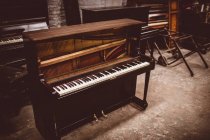 Velho piano de madeira na oficina interior — Fotografia de Stock