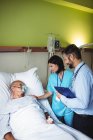 Nurse consoling senior patient with doctor in hospital — Stock Photo