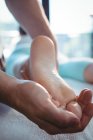 Обрезанный образ мужского физиотерапевта, делающего массаж ног пациентке — стоковое фото