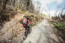 Vista posteriore di mountain bike equitazione su strada sterrata in montagna — Foto stock