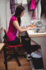 Costureira feminina costura na máquina de costura em estúdio — Fotografia de Stock