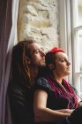 Romantisches junges Paar sitzt zu Hause am Fenster — Stockfoto
