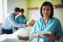 Медсестра с помощью цифрового планшета в стационаре — стоковое фото