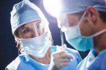 Smiling surgeons interacting in operation room at hospital — Stock Photo