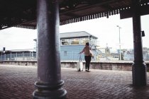 Rear view of woman standing at railroad station platform — Stock Photo