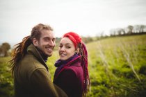 Портрет посміхаючись hipster стоїть пара в парку — стокове фото