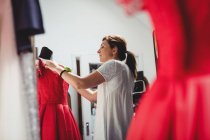 Criativa designer ajustando vestido no manequim — Fotografia de Stock