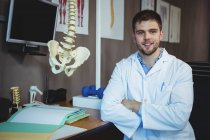 Portrait of physiotherapist sitting at desk in clinic — Stock Photo