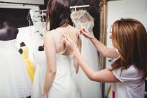 Donna che prova l'abito da sposa in studio con l'assistenza del designer creativo — Foto stock