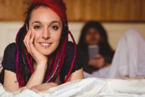 Портрет молодої жінки, що розслабляється чоловіком на ліжку вдома — стокове фото