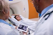 Médecins examinant le scanner IRM du cerveau sur tablette numérique à l'hôpital — Photo de stock