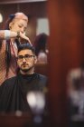 Uomo ottenere i capelli tagliati in negozio di barbiere — Foto stock