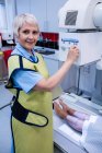 Médecin féminin utilisant un appareil à rayons X pour examiner le patient à l'hôpital — Photo de stock