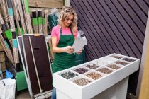 Female florist photographing pebbles in garden centre — Stock Photo