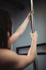 Close-up of pole dancer holding pole in fitness studio — Stock Photo