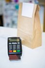 Payment terminal machine with credit card and package in shop — Stock Photo
