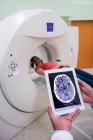 Medico che guarda la risonanza magnetica cerebrale su tablet digitale in ospedale — Foto stock