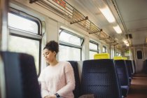 Young woman napping while sitting in train — Stock Photo