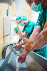 Gruppe von Chirurgen beim Händewaschen am Waschbecken im Krankenhaus — Stockfoto