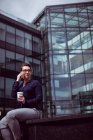 Geschäftsfrau spricht mit Handy gegen Bürogebäude — Stockfoto