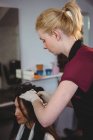 Cabeleireiro feminino tingir o cabelo de seu cliente no salão — Fotografia de Stock