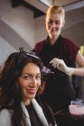 Femme coiffeuse teignant les cheveux de sa cliente dans le salon — Photo de stock