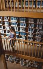 Frau liest Buch in Bibliothek — Stockfoto