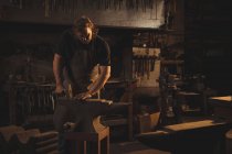 Blacksmith standing and working in workshop — Stock Photo