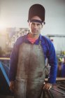 Портрет мужчины-сварщика, стоящего в мастерской и смотрящего в камеру — стоковое фото