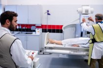 Ärzte untersuchen Patienten mit Röntgengerät im Krankenhaus — Stockfoto