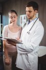 Physiotherapist explaining diagnosis to female patient in clinic — Stock Photo