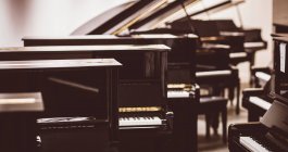 Vintage-Klaviere im Werkstattinnenraum arrangiert — Stockfoto
