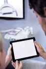 Cropped image of Dentist and dental assistant working together on tablet at dental clinic — Stock Photo