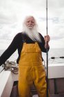 Портрет рыбака, стоящего на лодке с удочкой — стоковое фото