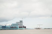 Міська сцена з будівлею терміналу аеропорту під хмарним небом — стокове фото