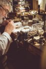 Horologist repairing a watch in the workshop — Stock Photo