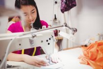Женщины-портнихи шьют на швейных машинах в студии — стоковое фото