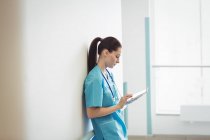 Infirmière utilisant une tablette numérique au mur de l'hôpital — Photo de stock