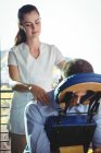 Fisioterapeuta feminina devolvendo massagem ao paciente masculino na clínica — Fotografia de Stock