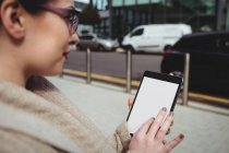 Женщина с цифровым планшетом на тротуаре — стоковое фото