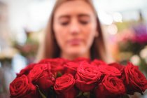 Fiorista femminile che tiene mazzo di fiori di rosa nel negozio di fiori — Foto stock